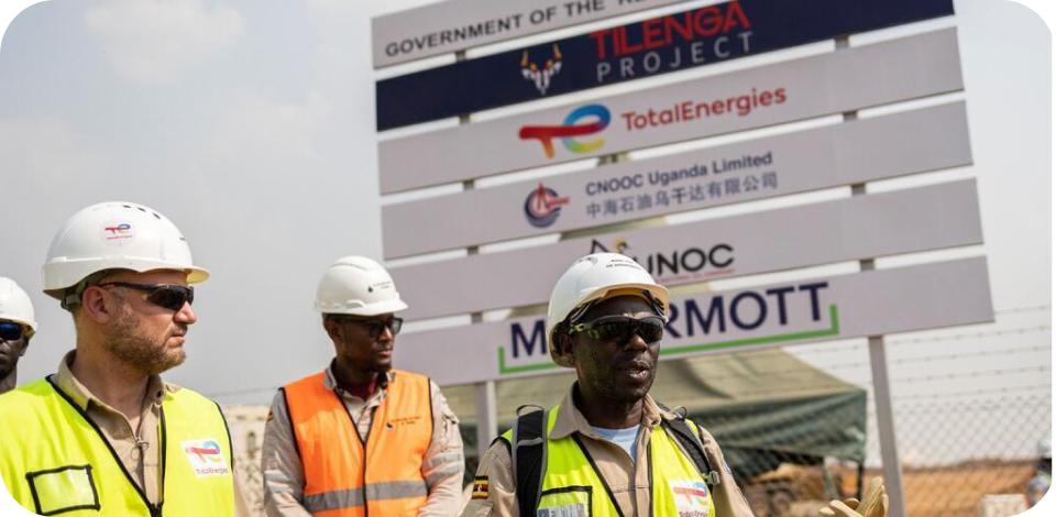 Trois hommes en habits de sécurité TotalEnergies aux abords du projets Tilenga.